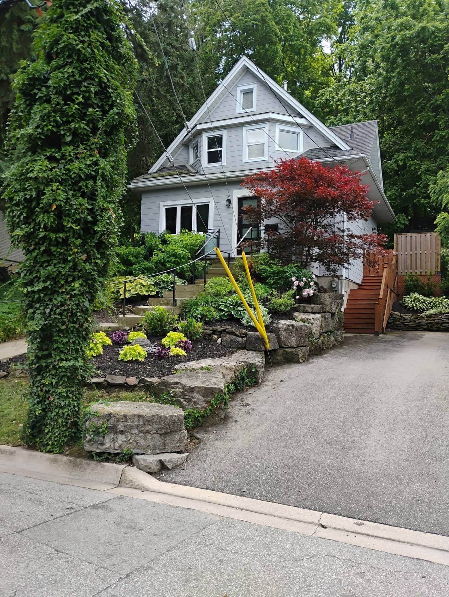 Renovated Grimsby home with a natural stone retaining wall and fresh garden beds