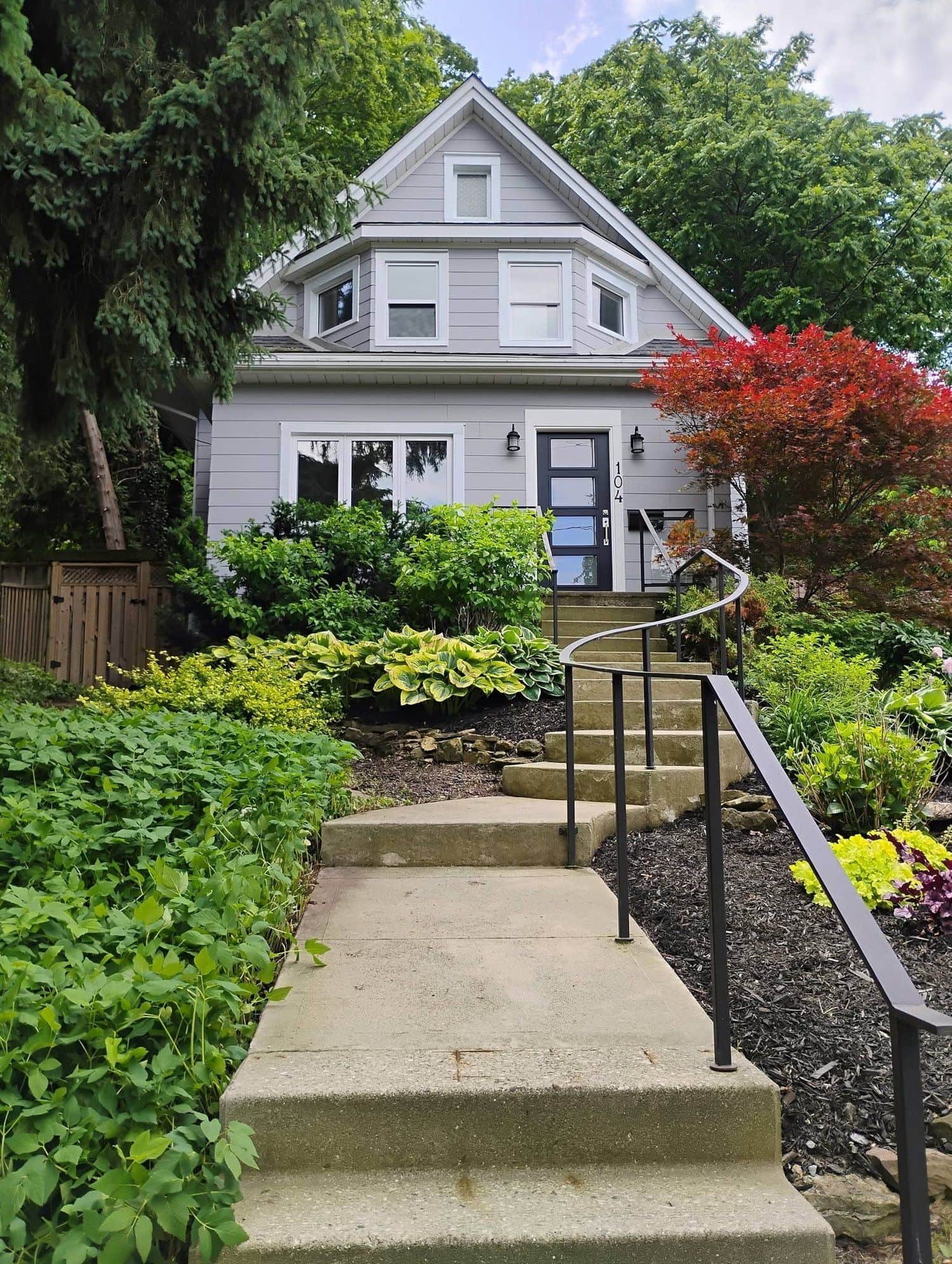 Front entrance with stone steps and layered garden plantings